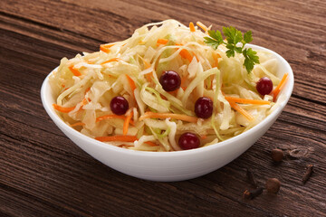 Cabbage salad with carrot on wooden rustic background.