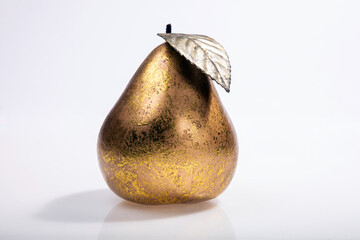 golden pear on a white background, gold plated decoration 