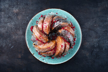 Traditional exotically bundt marble cocoa chocolate cake with icing sugar glaze and freeze dry raspberry topping served as top view on a Nordic design plate with copy space