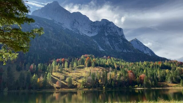 Theatrical autumn light of the Ferchen Lake with the golden autumn forest and Grünkopf mountain in the background, very close to the bavarian town of Mittenwald in Germany