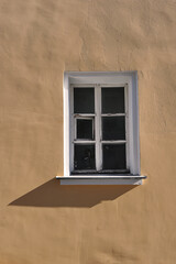an old wooden window on a yellow wall in a house in Kolomna