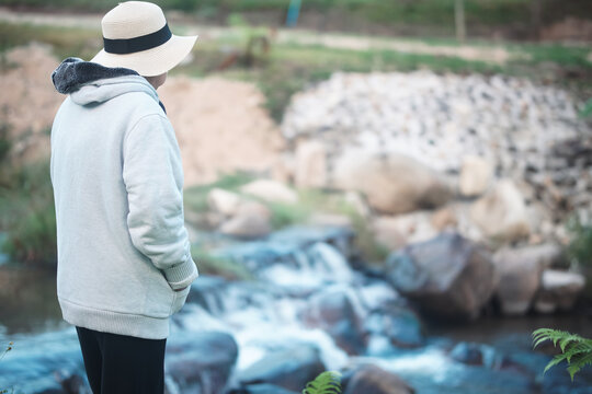 old woman relaxing near creek