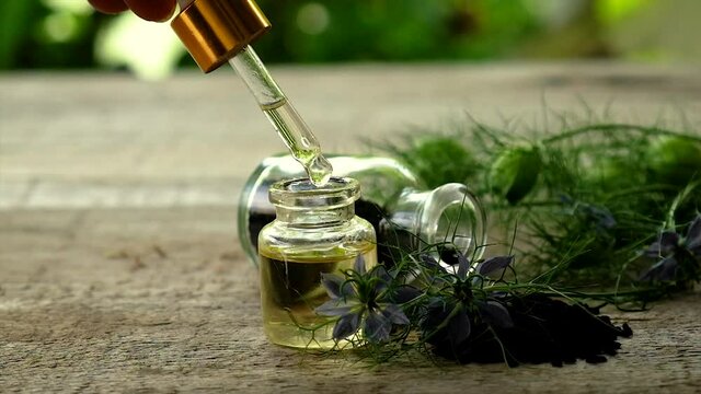 Black cumin oil in a bottle. Selective focus.