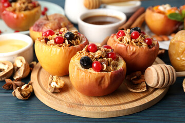 Concept of tasty food with baked apples on wooden table