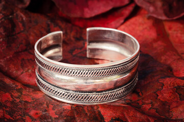 Close-up The silver  bangle on leaf   background.Vintage bangle,used for vintage background