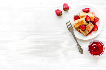 Sweet breakfast - rolled pancakes with strawberry and berry sauce