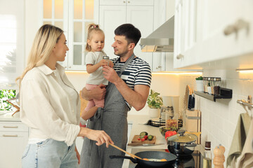 Happy lovely family cooking together in kitchen