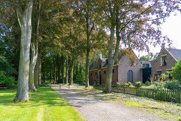 An avenue with trees along some outbuildings in a castle garden in Lisse, the Netherlands
