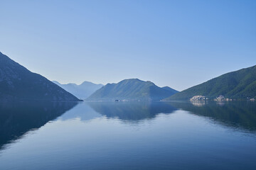 Morning seascape, reflection of mountains in sea water in Montenegro