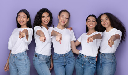 Mixed Women Pointing Fingers To Camera Posing Together, Purple Background