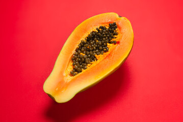 Papaya fruit on a orange background. Half papaya.