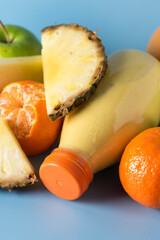 Freshly Blended Yellow and Orange Fruit Smoothie in Bottle Pineapple and Citrus Smoothie Healthy Drink Blue Background Vertical