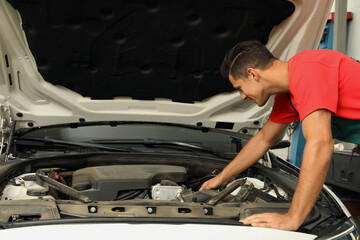 Fototapeta na wymiar Professional mechanic checking modern car at automobile repair shop