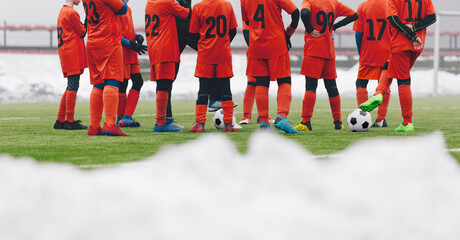 Football Players on Winter Soccer Training Camp. Young Boys Staning in a Circle With Coach on Grass Pitch. Snow Covering Grass Football Field