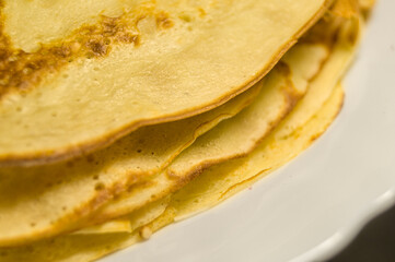Fresh homemade pancakes on a plate close-up. Shrovetide. Pancake day. Maslenitsa. Cooked food for the holiday. Soft focus