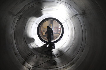 steel welder inside a large pipe