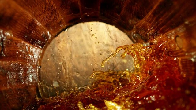 Super slow motion of pouring whiskey, rum or cognac inside the barrel. Filmed on high speed cinema camera, 1000fps. Ultimate composition view inside the wooden keg. Speed ramp effect.