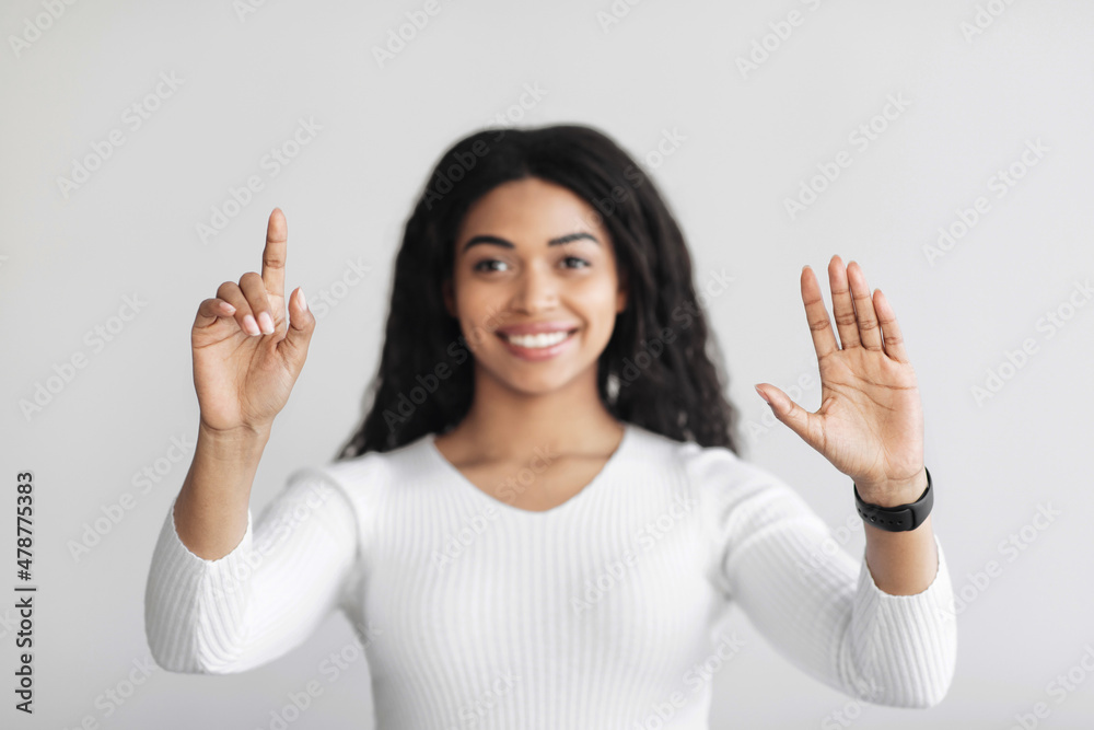Aufkleber happy black woman using virtual screen for work, pushing button on invisible screen over light wall