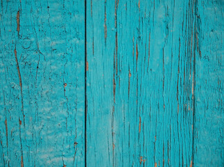 Fototapeta na wymiar A background of green peeling paint on an old wooden wall. Uneven texture of the boards.