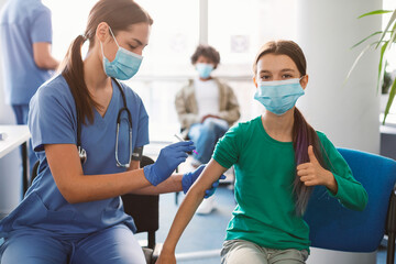 Girl Getting Vaccinated Against Covid-19, Showing Thumbs Up - obrazy, fototapety, plakaty
