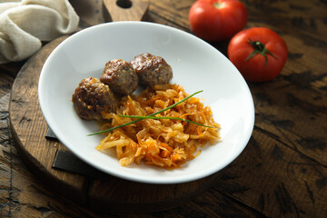Homemade meatballs with cabbage and tomato