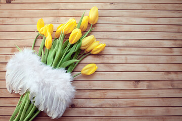 bouquet of yellow tulips with Angel winds on a  wooden background