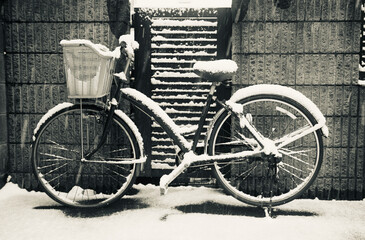 Fototapeta na wymiar black and white old snow covered bicycle on the street