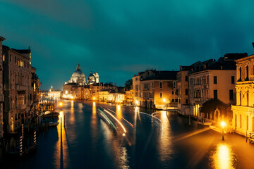 Colors of night in city with water canals, boats, lanterns and motion blurs in dark. Venice.