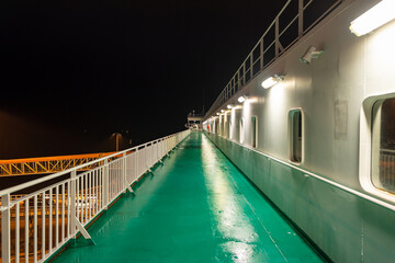 Promenade deck of a ro-ro ship and cruiseferry in the harbor of Ystad at night. The ferry connects the city of Świnoujście in Poland and Ystad in Sweden