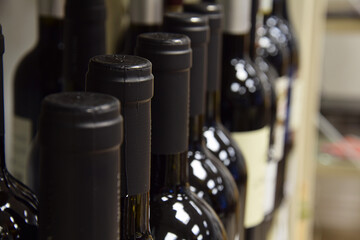 Wine bottles on wooden shelf in wine store