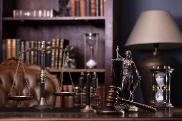 Fototapeta na wymiar Judge office. Gavel, scale, Themis sculpture on the desk. Law books in the bookshelf.