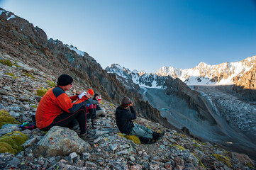 Group of trekkers climbers alpinists conquering Pik Uchitel peak from Racek Hut in Ala Archa Alpine National Park Landscape near Bishkek, Tian Shan Mountain Range, Kyrgyzstan, Central Asia.