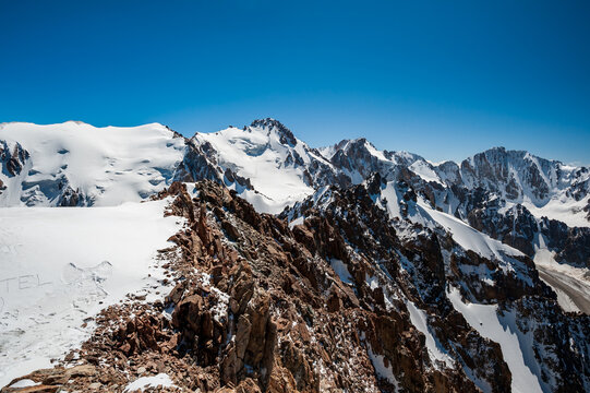 View from the top of Pik Uchitel peak with cross. Ala Archa Alpine National Park Landscape near Bishkek, Tian Shan Mountain Range, Kyrgyzstan, Central Asia.