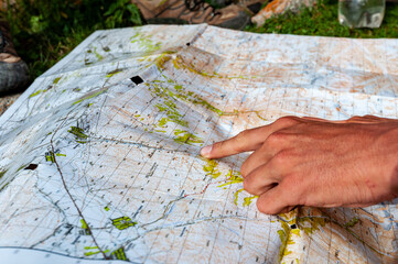 Hands palms showing trekking path on map with fingers measuring. Karakol valley, Issyk-kul region,...
