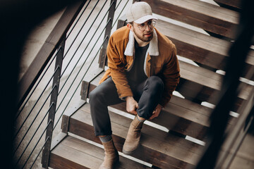 Man sitting on stairs in winter jacket