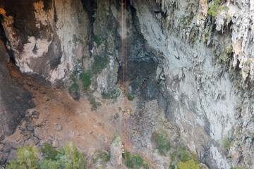 Aerial top view of tourist sprinkle the rope at Spirit Well Cave, Pang Mapha District, Mae Hong Son, Thailand. Adventure activity lifestyle. People. Tourist attraction landmark. Nature landscape.
