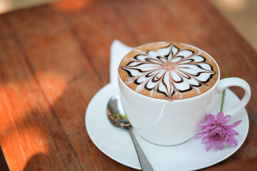Latte art coffee in white cup on wood table .