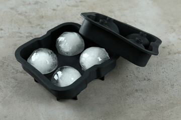 Frozen ice balls in mold on grey table