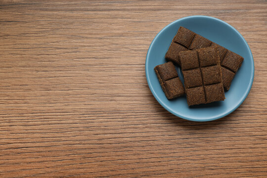 Blue plate with delicious and healthy hematogen on wooden table, top view. Space for text