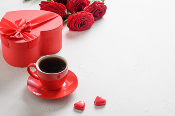 Valentine's day coffee, red gift and red roses on white background. Invitation to dating. Close up. Copy space.