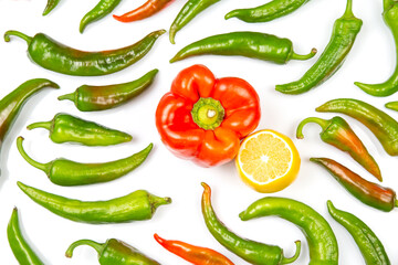 green hot peppers and red and yellow bell peppers on a white background. vitamin vegetables for health