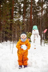  Little todler  on   winter walk near   snowman