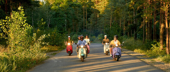 Happy young friends driving scooter motorbikes © Svitlana