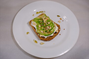 Avocado sandwiches, half of avocado, with peanuts and pumpkin seeds on a white background