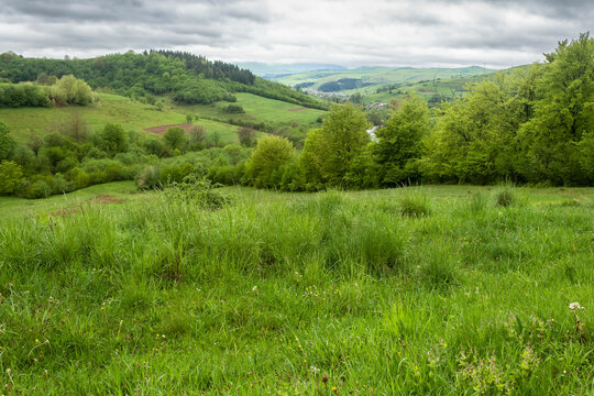 wonderful countryside rural landscape. beautiful view of idyllic mountain scenery in the carpathians. fresh green forests and meadows. overcast rainy morning. village in the distant valley