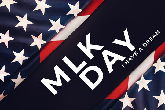 Black background with American Flag and text abbreviation MLK. Flat lay. Happy Martin Luther King Day concept