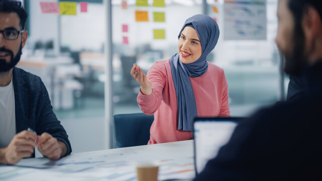 Diverse Modern Office: Portrait of Successful Young Muslim Businesswoman Wearing Hijab Leads Meeting, talks about Company Growth. Creative Digital Entrepreneurs Work on e-Commerce Project.