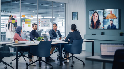 Businesspeople do Video Conference Call with Big Wall TV in Office Meeting Room. Diverse Team of Creative Entrepreneurs at Big Table have Discussion. Specialists work in Digital e-Commerce Startup - obrazy, fototapety, plakaty