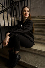 Girl in black on the stairs. Black, beige, yellow