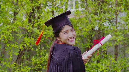 Attractive Asian Women Student Graduate in cap and gown celebrating with certificate in hand and so proud happiness in Commencement day,Congratulation of student in graduation day,Education Success